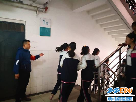 导护教师引导学生下楼疏散