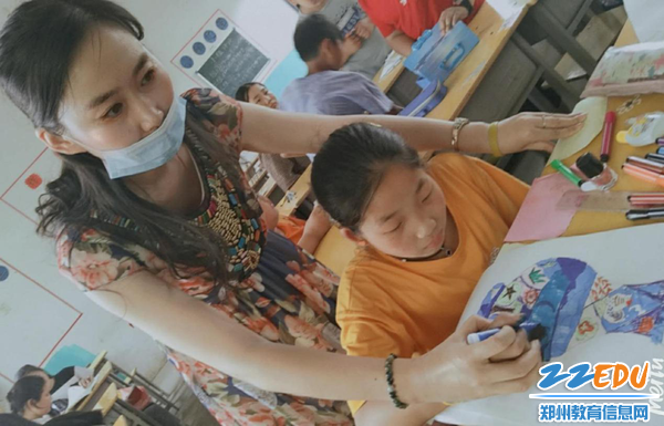 1 汤春叶老师在美术课堂上认真辅导学生绘画